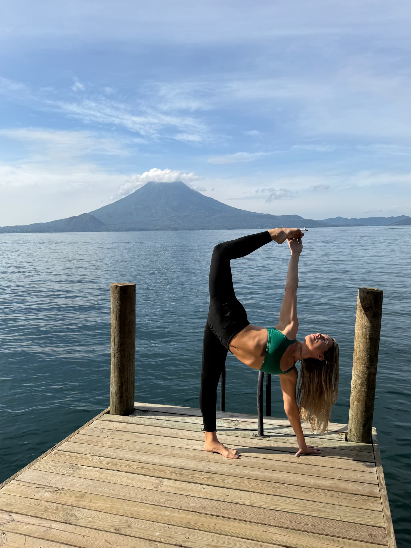 Half moon pose on the dock with the volcano across Lake Atitlán
