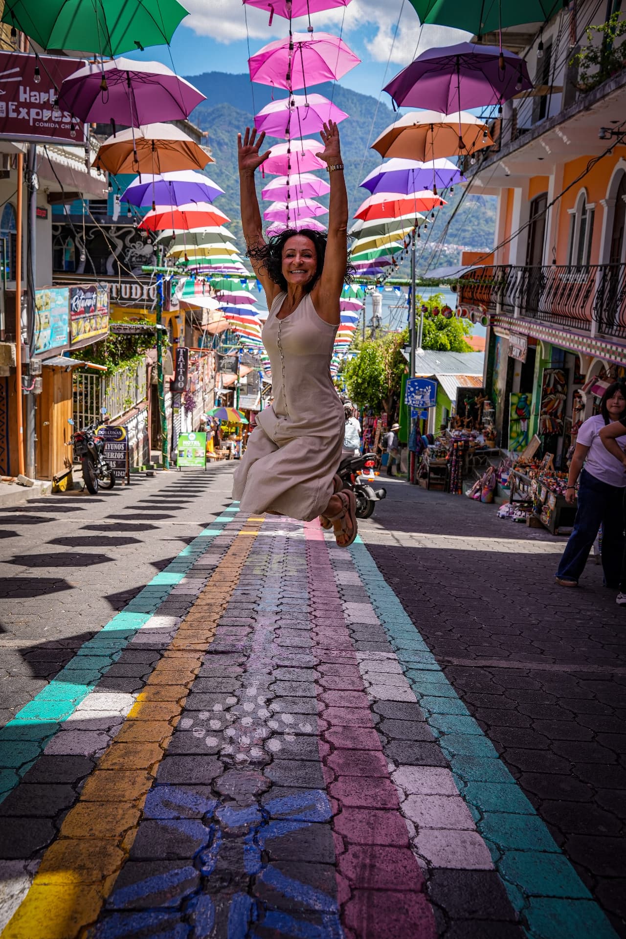 Joyful leap on the rainbow street beneath the umbrellas